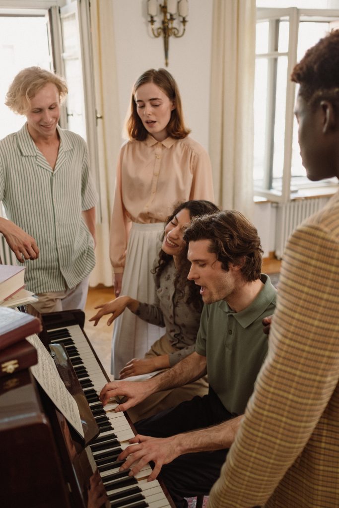 a group singing around a piano 
