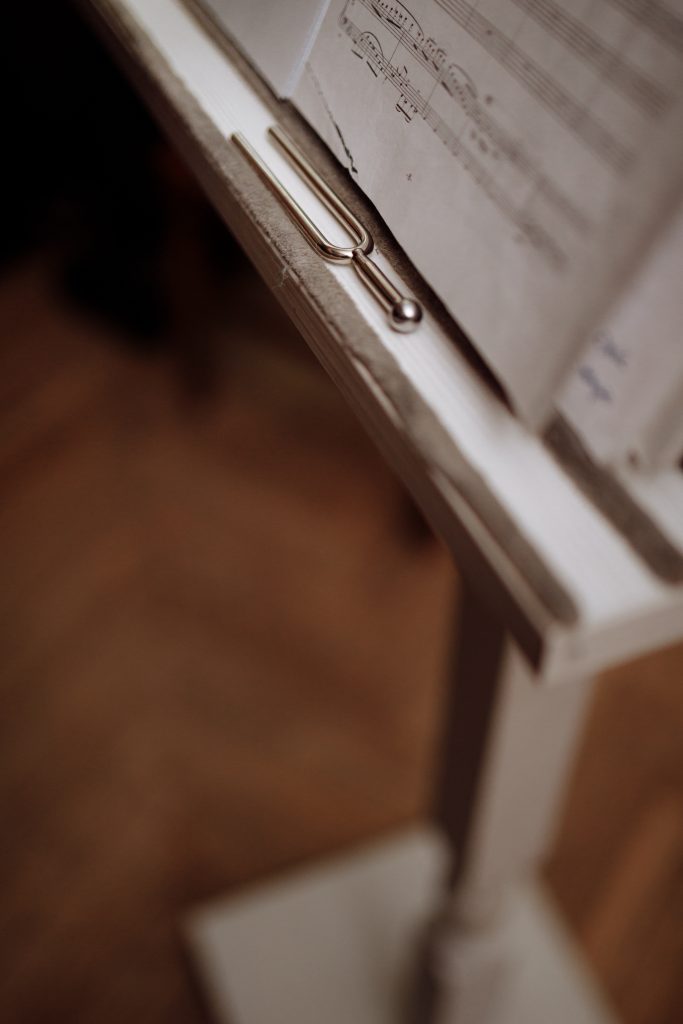 A close up of a tuning fork on a music stand.
