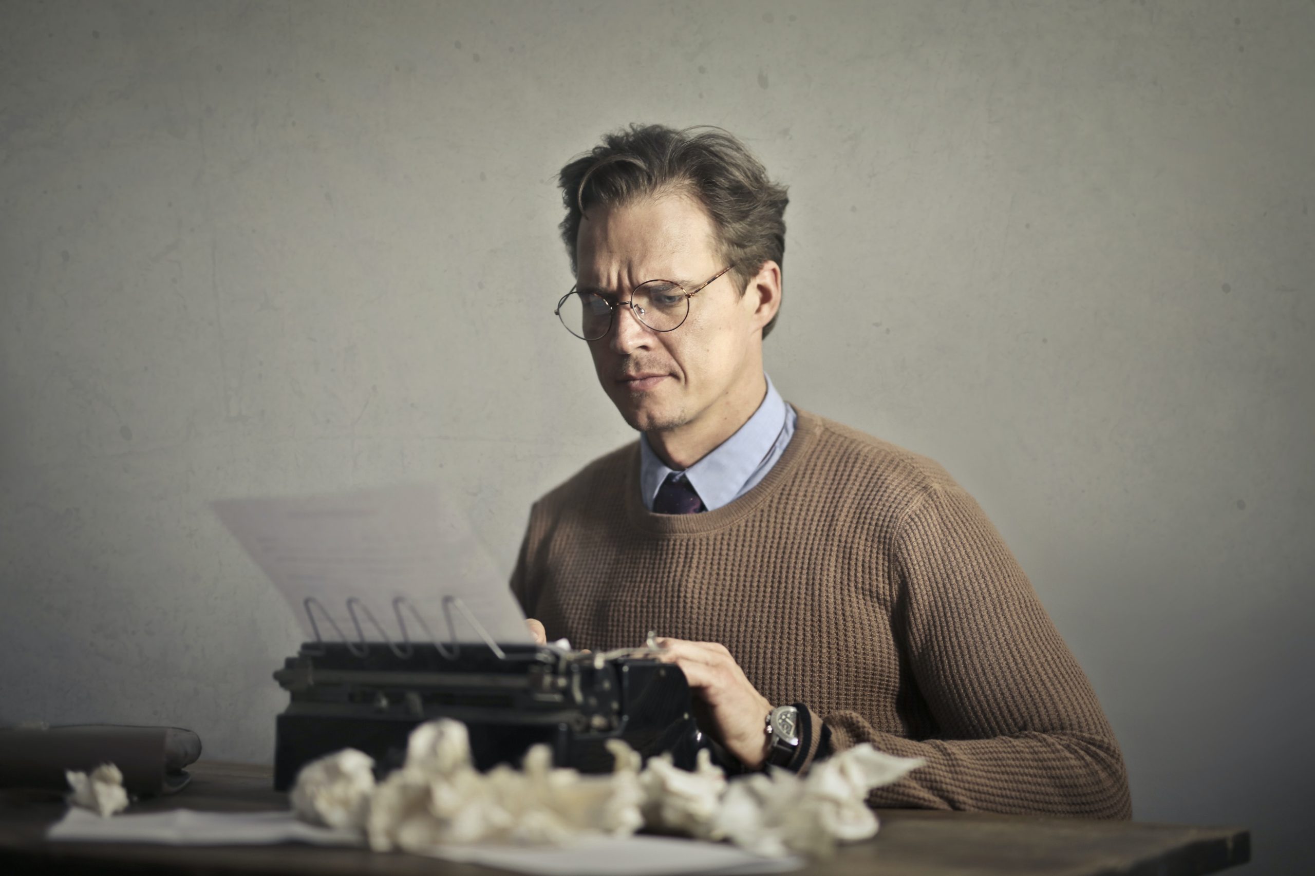 A perturbed man writing at a typewriter