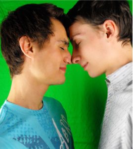Two boys touch foreheads and noses.
