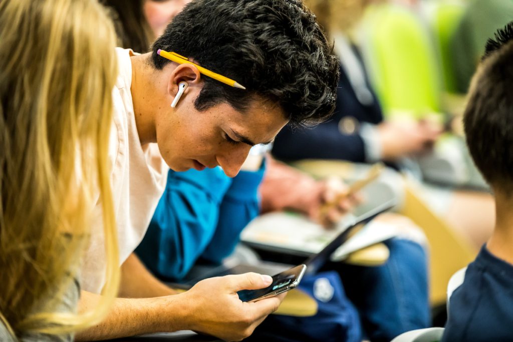 Student working on a mobile phone.