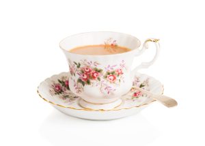 Cup of English breakfast tea in vintage teacup and saucer with antique spoon on a white background