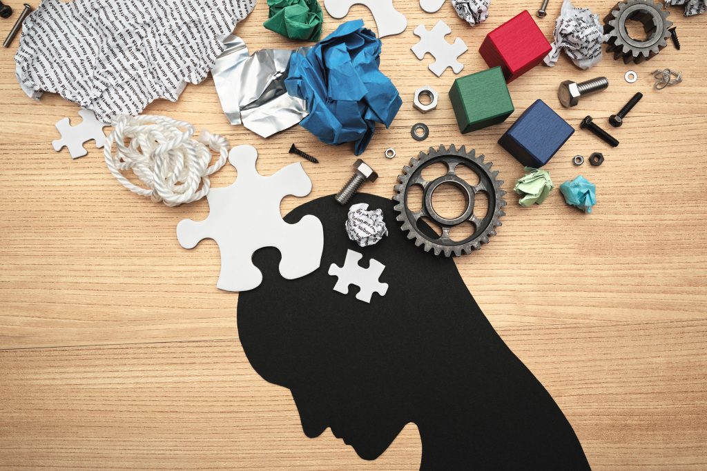 Silhouette of a person's head with various items above it representing mental fatigue.