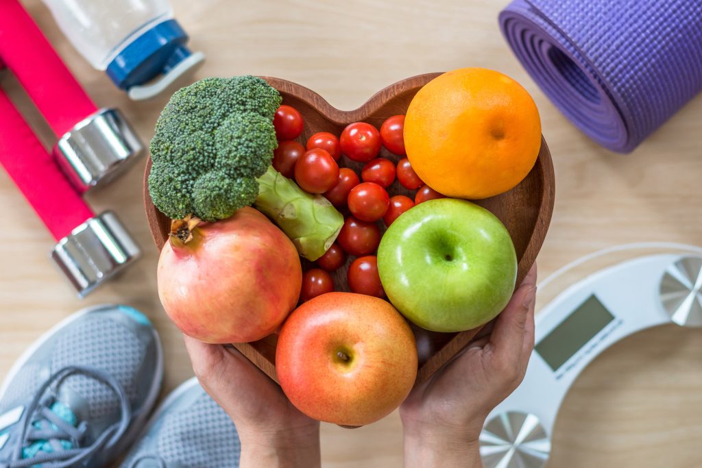 Image of a bowl of fruit with exercise gear in the background.