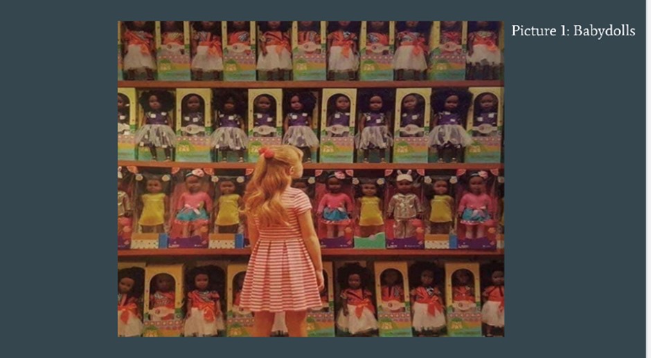 A girl standing in front of several dolls at a store.