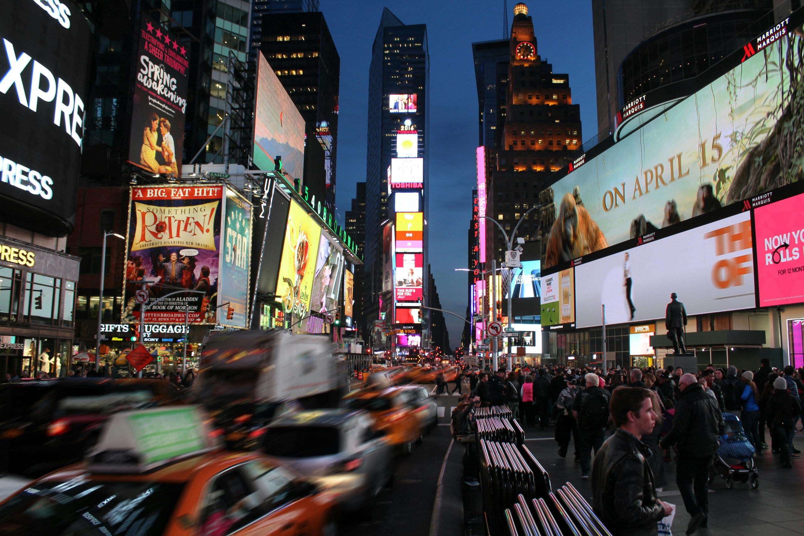 A busy cityscape at nighttime, ads plastered everywhere and glowing in the night.