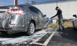 photo of a man washing a car