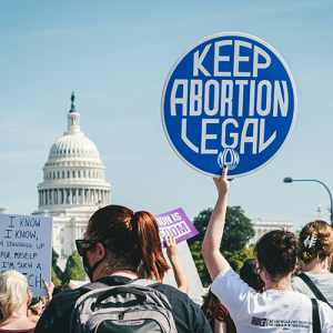 A woman holding a "keep abortion legal" sign at a protest