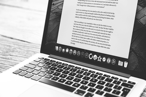 Black and white photo of a laptop showing a word processor window