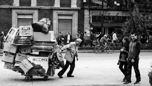 Old man pulling heavily laden cart