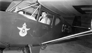 An old photo of a pilot sitting in an old military prop plane.