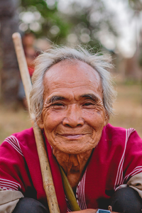 A warm, grinning older man from Myanmar looking at the camera.