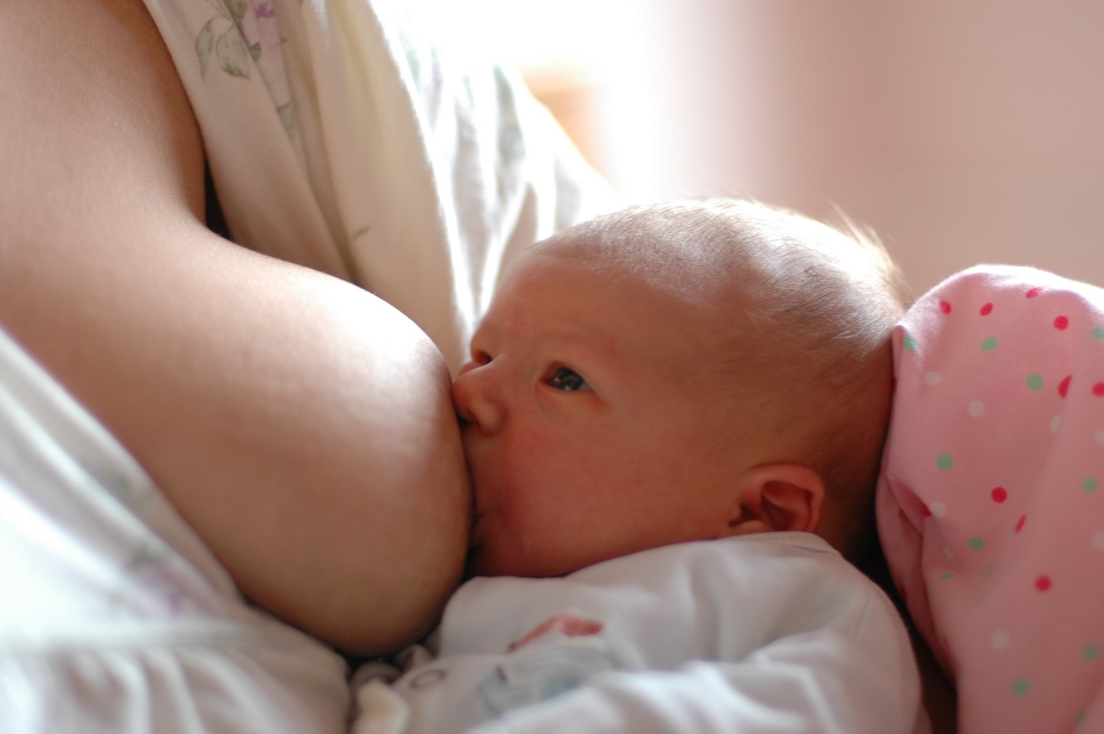 Photograph of a baby breastfeeding.