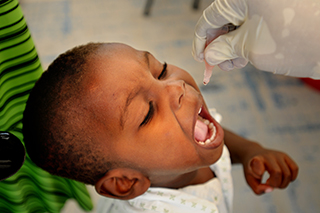 Child receiving the oral polio vaccine at a USAID clinic in Haiti.