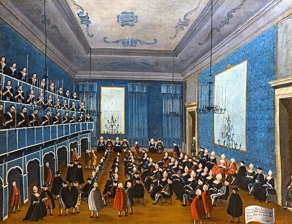 A formal gathering in an elegant hall with blue walls and chandeliers.