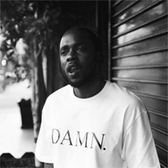 Person wearing a "DAMN." t-shirt standing in front of a metal shutter.