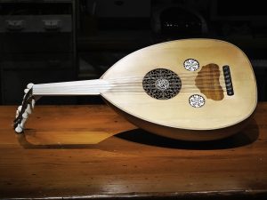 A traditional oud on a wooden table with intricate rosette designs.