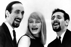 Three people smiling in a black and white photo.